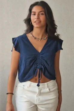 Camiseta azul marino con volantes en los hombros y frunce en el pecho