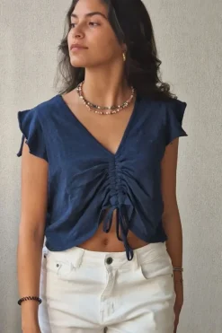 Camiseta azul marino con volantes en los hombros y frunce en el pecho